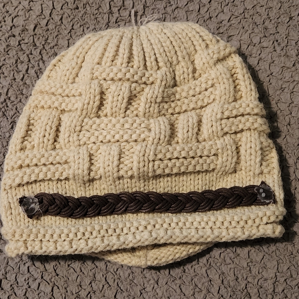 Super cute cream beanie with brown rope accent.